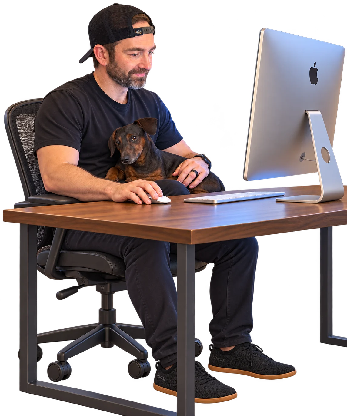 Kyle Ledbetter at his desk with his dachshund